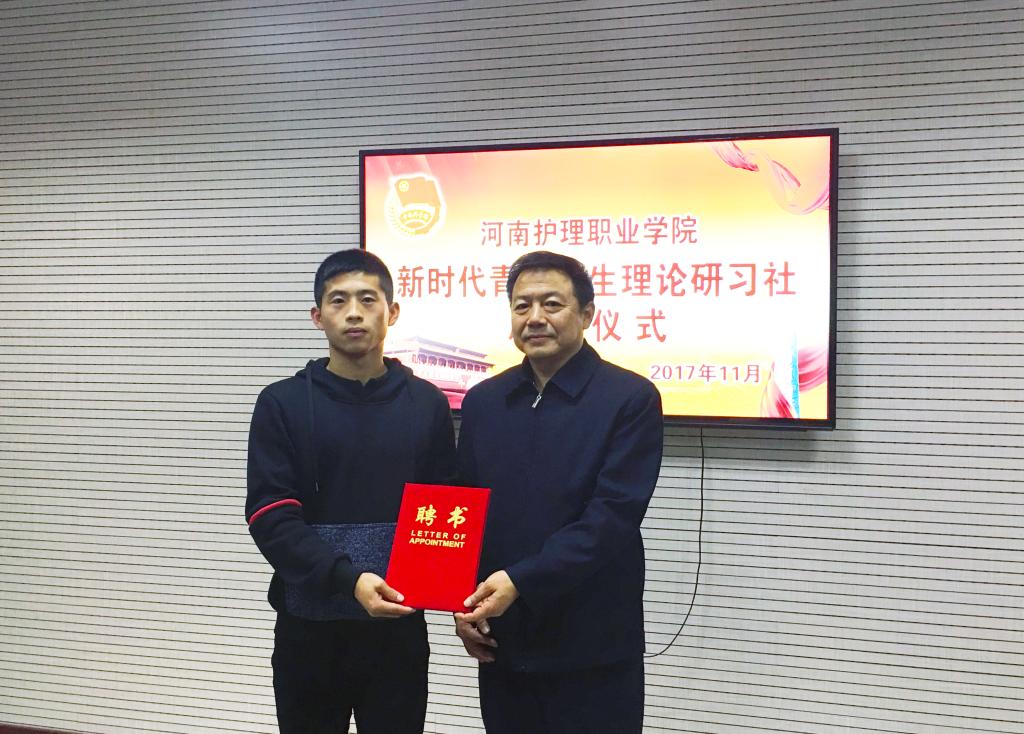 学院党委副书记、工会主席胡景团(右)为理论社团负责人颁发聘书